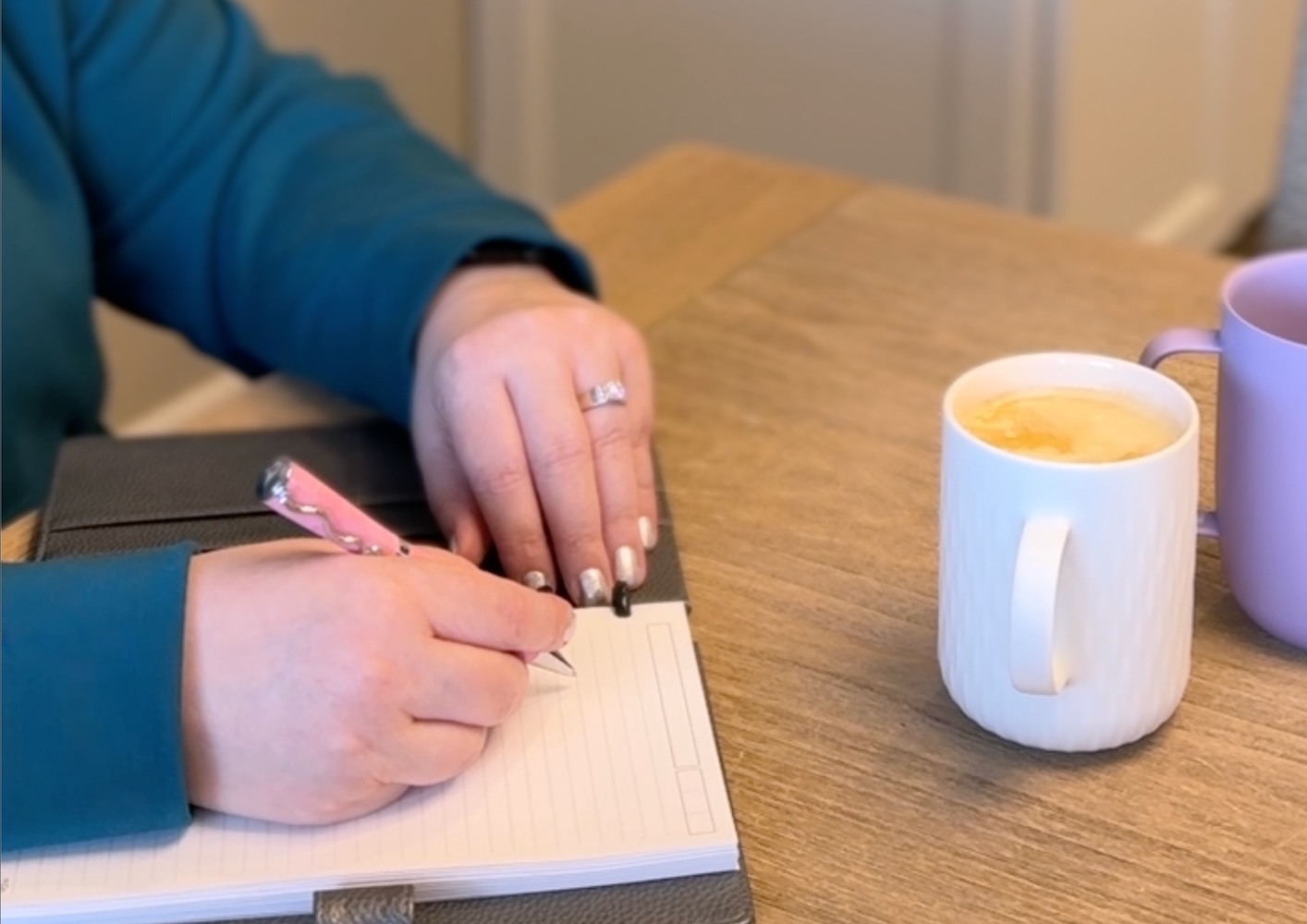 Person writing observations in a notebook while learning their body's patterns and warning signs.